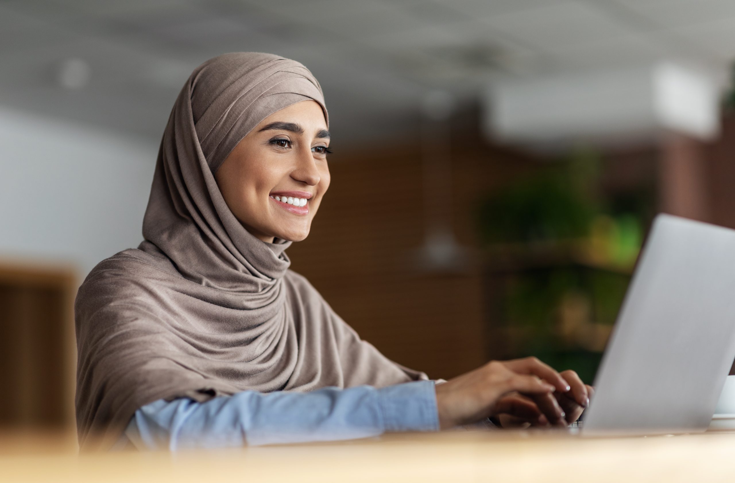 Cheerful,Arab,Lady,In,Hijab,Working,Online,At,Cafe,,Using